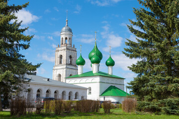 Fototapeta na wymiar View of the bell tower and domes of the Trinity Cathedral on a sunny May day. Poshekhonye, Yaroslavl region. Russia