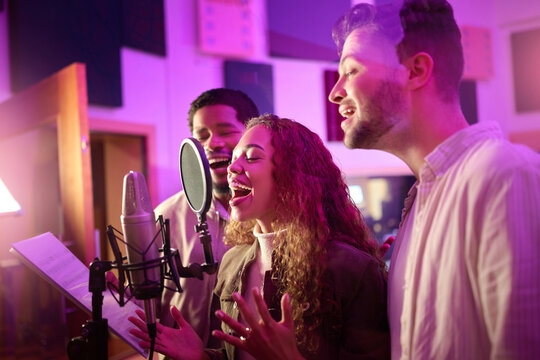 Woman, face or singing group on neon studio microphone in backup singers album, song lyrics or radio recording. Artist, musician or friends in production sound, voice media or light label performance