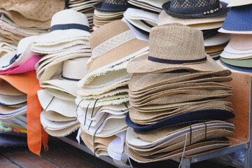Counter of a street seller of hats in a resort place. A variety of woven hats for women and men are...