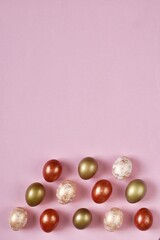 Colorful Easter Eggs bottom border over a pastel pink background. Vertical banner with Copy space. Flat lay composition