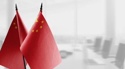 Small flags of the China on an abstract blurry background