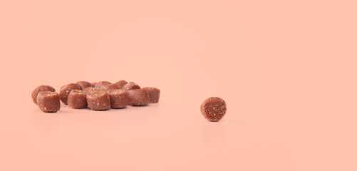 Dog treat with defocused pile of treats on soft pink background. Mini training treat sizes ideal...