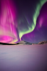 Stunning pink Night Sky Photography of Northern Lights over Snowy Landscapes