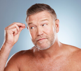 Obraz premium Skincare, tweezers for eyebrow and face of man on blue background for wellness, facial and microblading. Beauty salon, cleaning and male with tool for grooming, self care and hair removal in studio