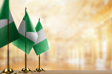 Small flags of the Nigeria on an abstract blurry background