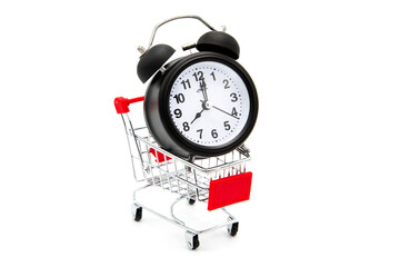 Supermarket shopping cart with alarm clock isolated on white background.
