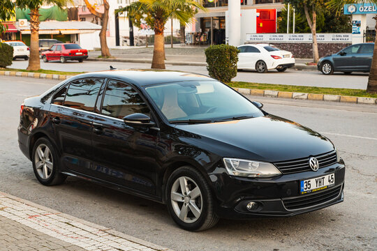 Side, Turkey -January 27, 2023:  black Volkswagen Jetta is parked  on the street on a warm summer day against the backdrop of a buildung, shops