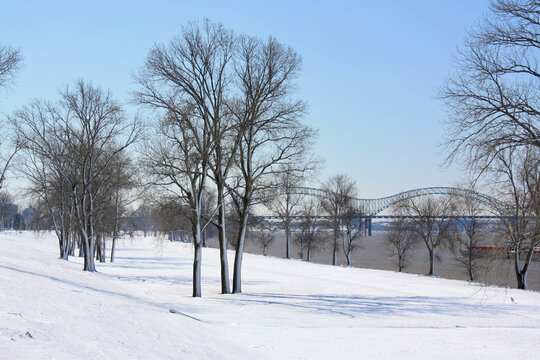 Snow on the eastern bank of Mississippi River in Memphis, Tennessee. Hernando do Soto Bridge is in the background.