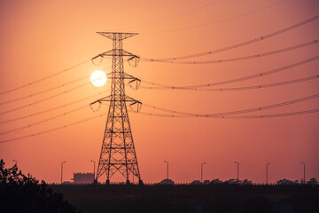 Fototapeta premium A view of a sunset full of power at twilight. High-voltage electric towers in the foreground. Marsonda Bridge, Tainan City, Taiwan