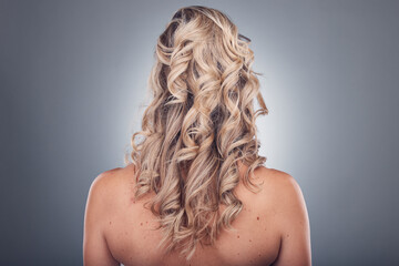 Hair care, beauty and woman with curly hairstyle texture after salon treatment in a studio. Gray...