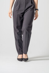 Female legs in strict business black trousers and high-heeled shoes close-up on a white background / Business woman concept