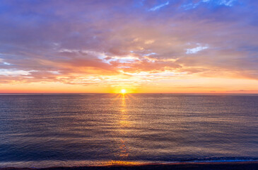 Obraz premium view at sunrise or sunset in sea with nice beach , surf , calm water and beautiful clouds on a background of a sea landscape