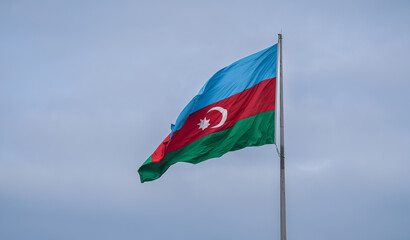 Close up photo with flag of Azerbaijan waving against cloudy sky. Concept image for Azerbaijan, Baku city.