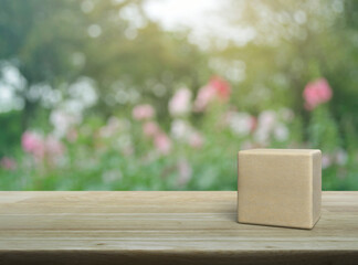 Wood block cube on wooden table over blur pink flower and tree in park