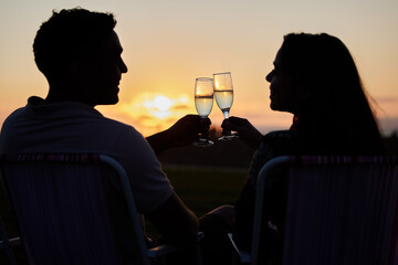 Couple, toast and sunset love of people silhouette with champagne glasses outdoor. Happy, alcohol and valentines day celebration in nature with cheers together on a date with happiness on anniversary © Beaunitta Van Wyk/peopleimages.com
