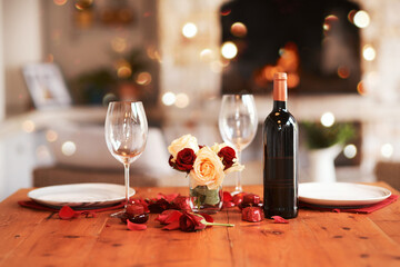 Romantic, dinner table and setup for valentines day, fine dining or date at indoor night restaurant. Interior diner with wine glasses prepared with roses and champagne for evening couple reservation