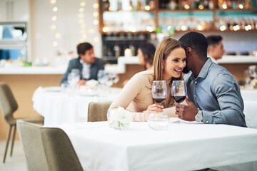 Restaurant date, couple and wine celebration of a man telling a secret at a dinner table. Anniversary celebration, valentines day smile and wine at night with love, care and conversation together