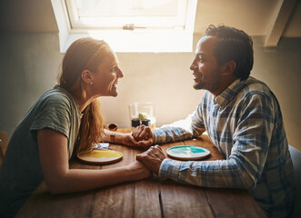 Love, couple and holding hands at home on table, talking and bonding together. Valentines day, romance diversity and affection of man and woman on date, having fun and enjoying quality time in house.