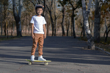 Fototapeta premium Teenager in stylish jeans and t-shirt skating in the park