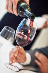 Hands, glass and waiter pouring wine for serving, catering or working at restaurant for customer service. Hand of diner worker providing alcohol in champagne glasses for hospitality or fine dining