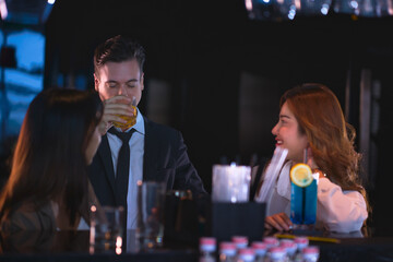 Night party with working team to hangout after hard work and drinking cocktail by businessman