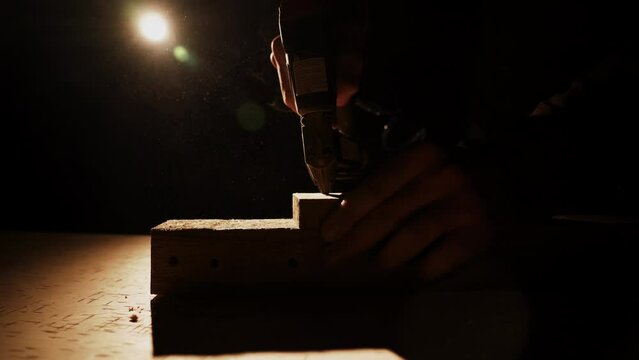 carpenter using nail gun or brad nailer tool on wood box in a workshop ,furniture restoration woodworking concept. selective focus 4k