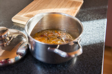 A pot of noodle soup on kitchen counter