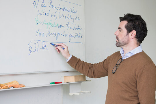 Teacher explaining on white board School, Bavaria, Germany
