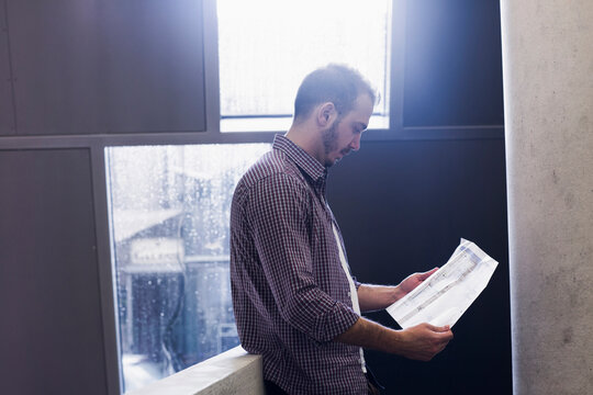 Young architect looking at blueprint in an office,Freiburg im Breisgau, Baden-W&uuml;rttemberg, Germany