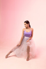 Young woman in a tulle skirt posing on a white background.