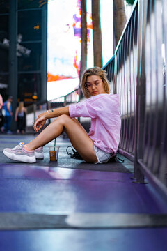 Las Vegas. girl female sits on the sidewalk, smokes, drinks coff