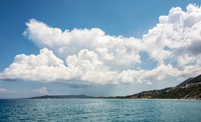 Fototapeta premium Seascape. Thick Cumulus clouds over the sea coast.