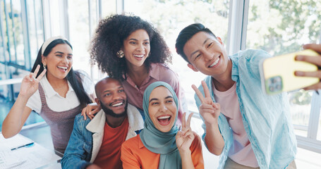Obraz premium Phone, team building or happy employees take a selfie in an office room at work for social media on a break. Smile, friends or fun colleagues with pride, diversity or motivation taking group pictures