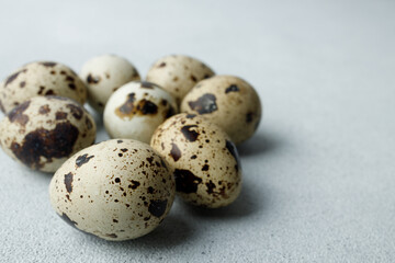 Quail eggs on light gray background. Easter concept. Natural, organic farm products. Close up. Copy space. Place for text