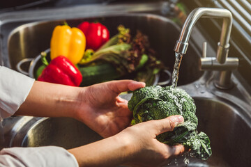 Hand of maid washing tomato fresh vegetables preparation healthy food in kitchen