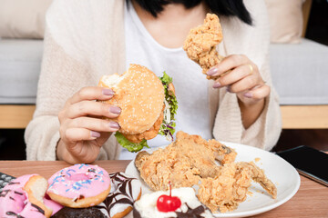 unhealthy woman over eating fast food burgers, fired chicken, donuts, and desserts,  Binge Eating...