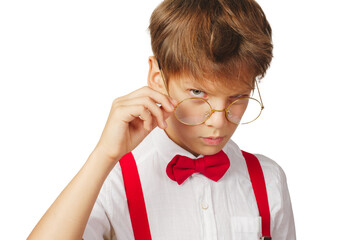 A stylish young boy in red suspenders and a bow tie looks suspiciously from under his glasses on a...