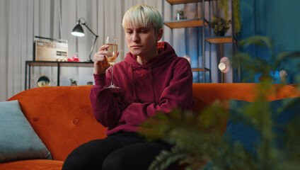 Sad woman girl with short hair sitting at home looks pensive of unrequited love, suffers from...