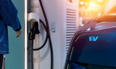 Electric car charging with station. man connecting a charging cable to a car from an electric car...