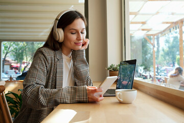 Portrait of young beautiful woman dressed in smart casual style sitting in a coffee shop with her...