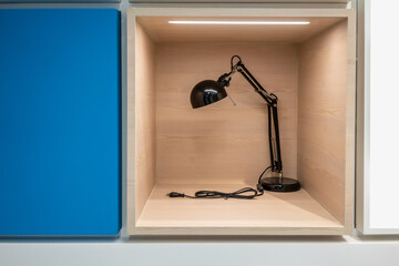 Black table lamp in wooden box for display in store or mall.