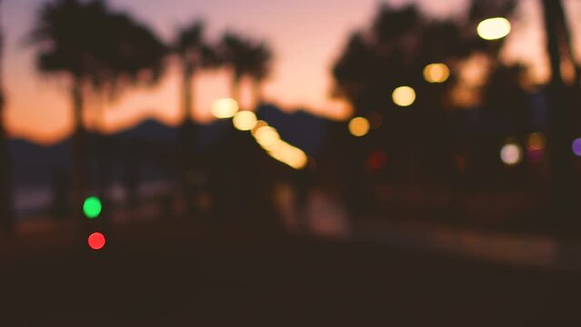 Blur background of silhouette of palm trees of sea beach against the backdrop of setting sun on sunset sky. Top view. Panoramic view
