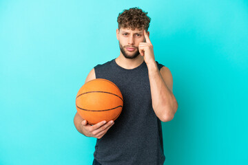 Handsome young man playing basketball isolated on blue background thinking an idea