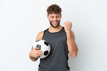 Young handsome caucasian man isolated on white background with soccer ball celebrating a victory