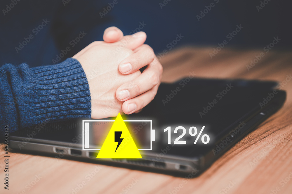 Poster young man is angry and frustrated when he learns that his the laptop computer's battery is dead and 