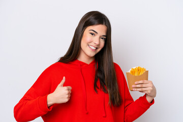 Young Brazilian woman catching french fries isolated on white background with thumbs up because something good has happened