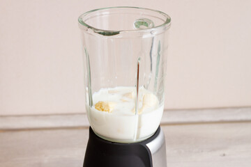 White banana milkshake smoothie in blender.
