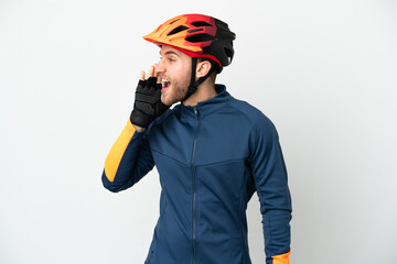 Young cyclist man isolated on white background shouting with mouth wide open to the side