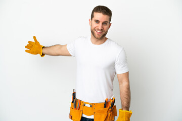 Young electrician man over isolated white wall extending hands to the side for inviting to come