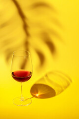 Glass of red wine on a yellow background.